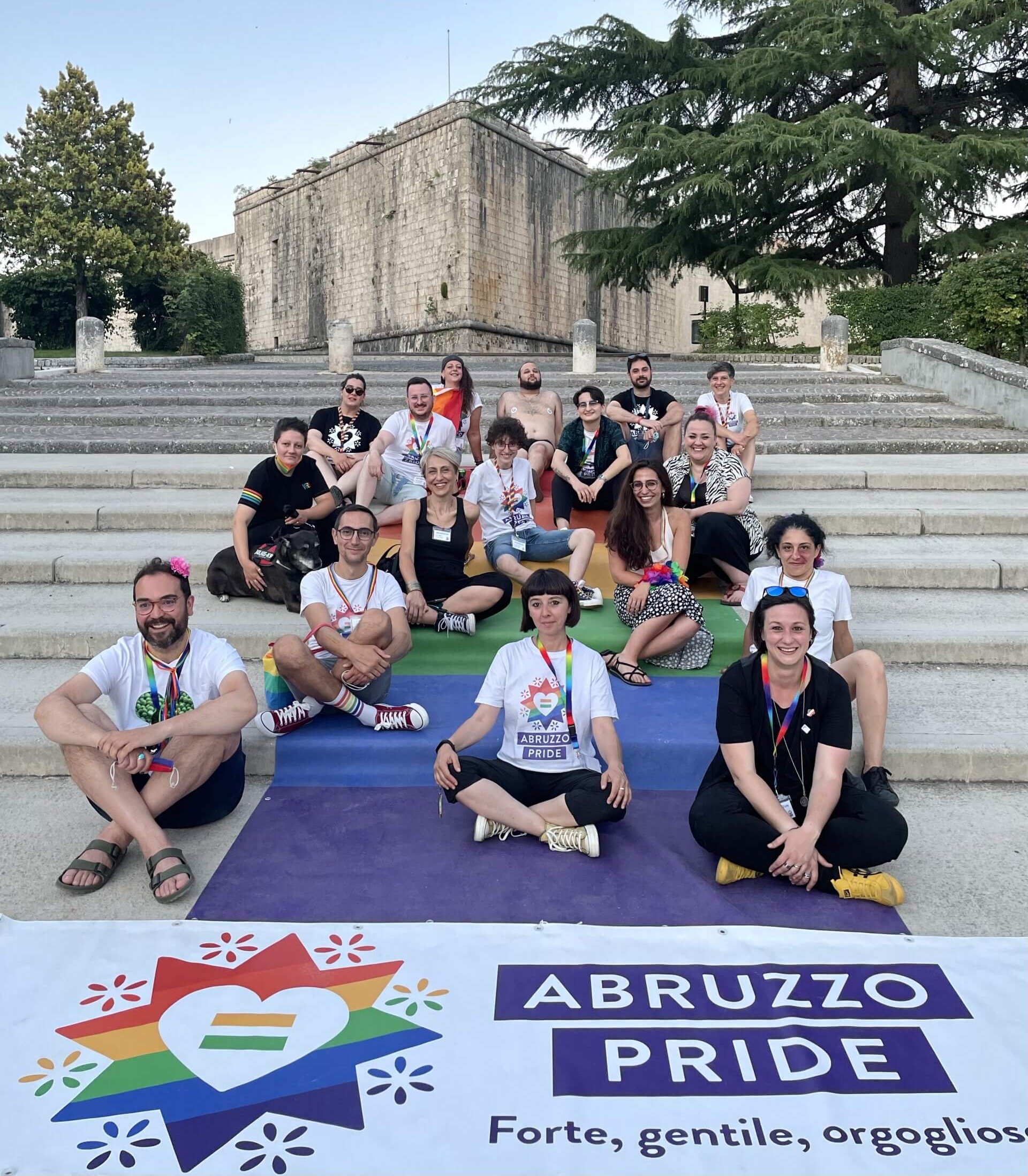 Le persone del Coordinamento Abruzzo Pride intorno alla bandiera arcobaleno nell'edizione 2021 a L'Aquila